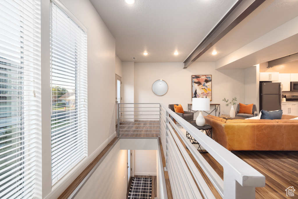 Hall featuring recessed lighting, wood finished floors, and an upstairs landing