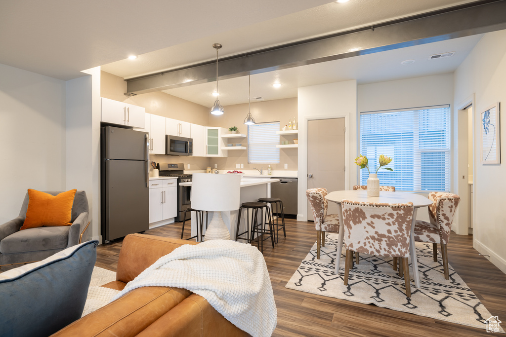 Interior space with visible vents, dark wood-style flooring, baseboards, and beam ceiling