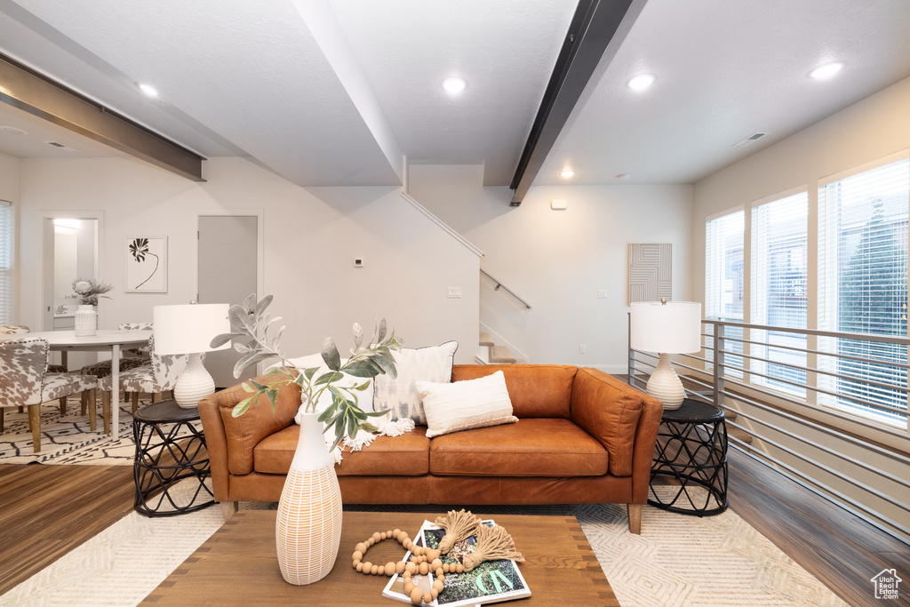 Living room with recessed lighting, beam ceiling, stairway, and wood finished floors