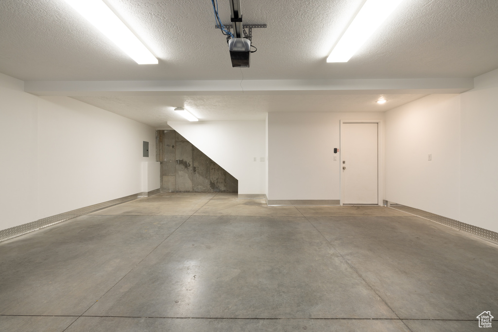 Garage with baseboards and a garage door opener