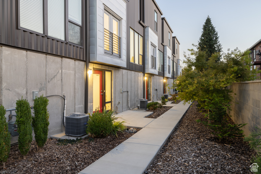 Exterior space with board and batten siding, fence, and cooling unit