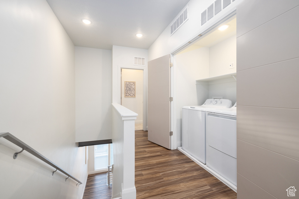 Washroom with laundry area, visible vents, washing machine and dryer, and dark wood-type flooring
