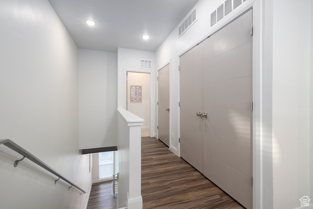 Corridor featuring visible vents, recessed lighting, dark wood-style floors, and an upstairs landing