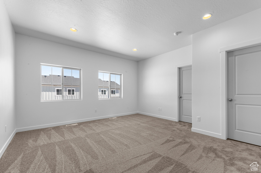 Unfurnished bedroom featuring a textured ceiling, carpet, recessed lighting, baseboards, and visible vents