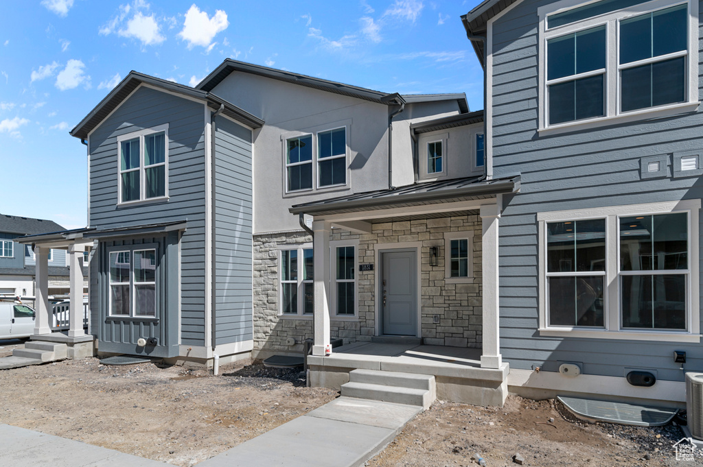 Multi unit property with cooling unit, metal roof, stone siding, and a standing seam roof
