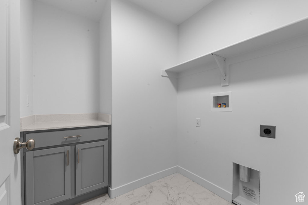 Laundry area featuring hookup for an electric dryer, cabinet space, baseboards, hookup for a washing machine, and marble finish floor