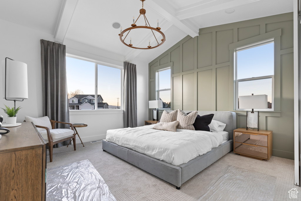 Bedroom with light colored carpet, baseboards, a notable chandelier, and vaulted ceiling with beams