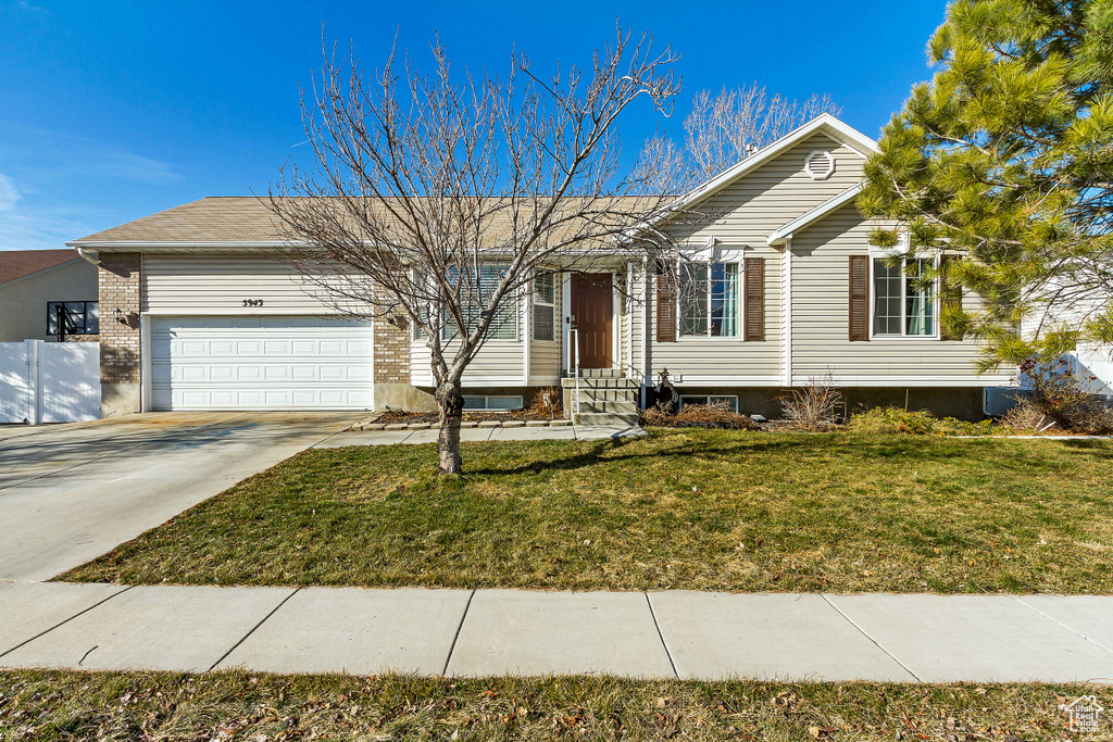 Ranch-style home with a garage, driveway, and a front yard
