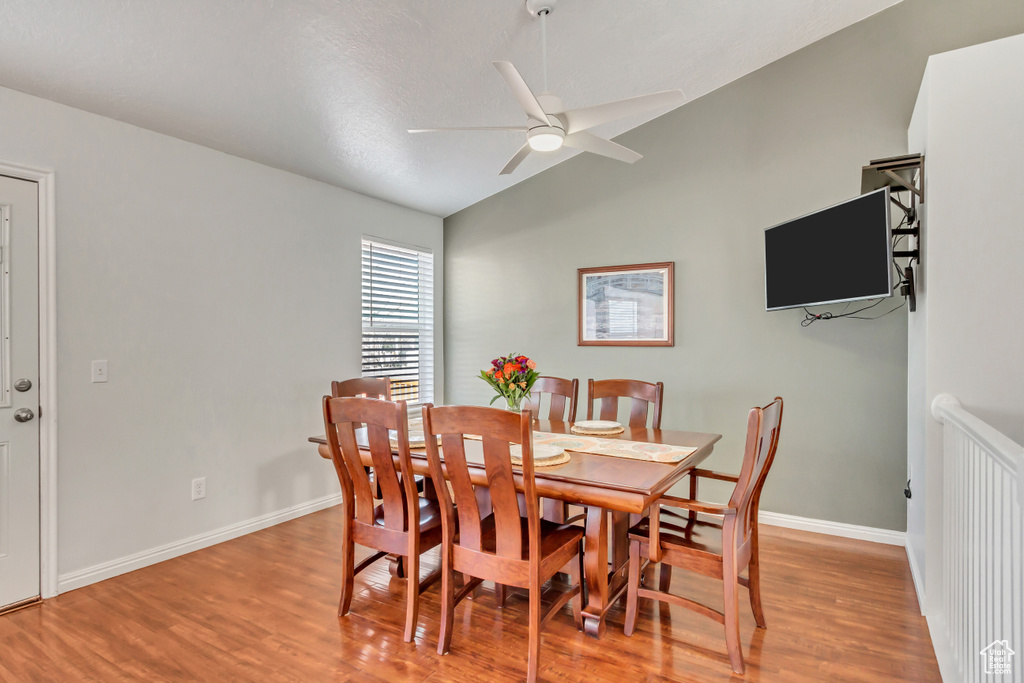 Dining room with baseboards, ceiling fan, wood finished floors, and lofted ceiling