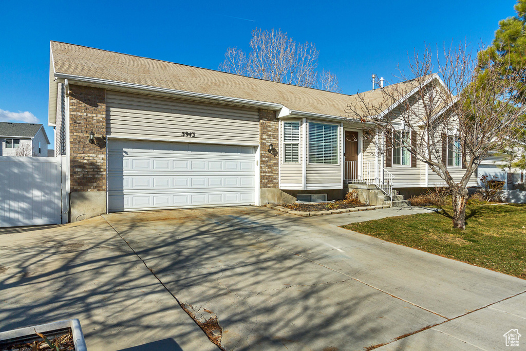 Single story home featuring brick siding, an attached garage, and concrete driveway