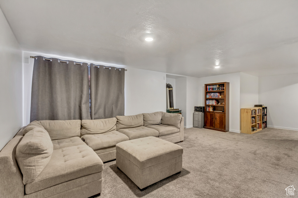 Living room featuring baseboards, recessed lighting, and light colored carpet