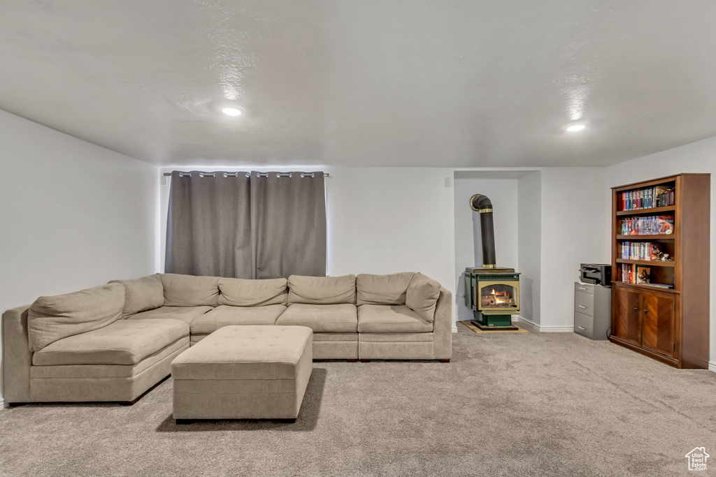 Living area with baseboards, a wood stove, recessed lighting, and carpet flooring