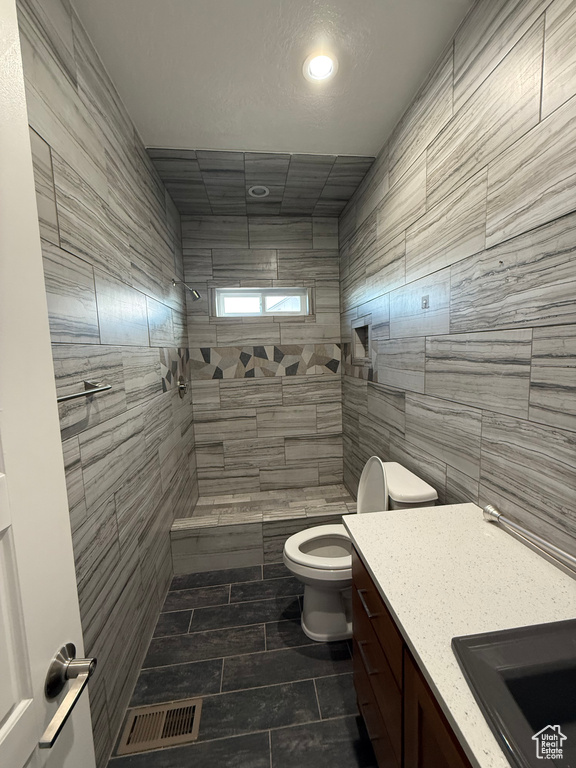 Bathroom with visible vents, tile walls, toilet, recessed lighting, and tiled shower