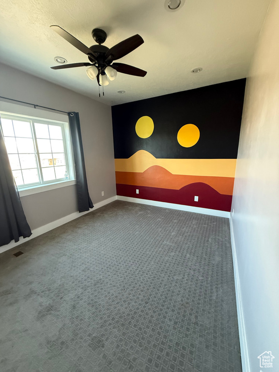 Carpeted spare room with baseboards, recessed lighting, ceiling fan, and an accent wall