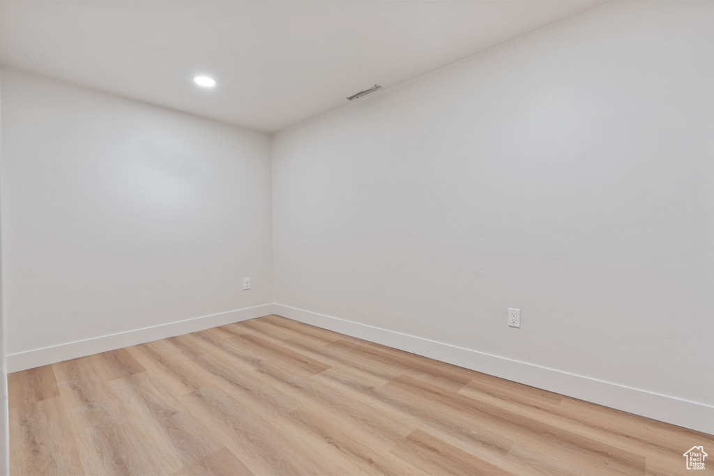Spare room with recessed lighting, baseboards, light wood-type flooring, and visible vents
