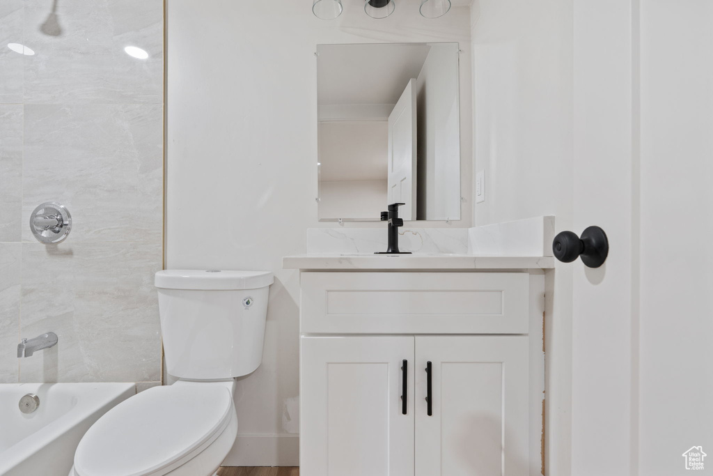 Bathroom with vanity, baseboards, toilet, and  shower combination