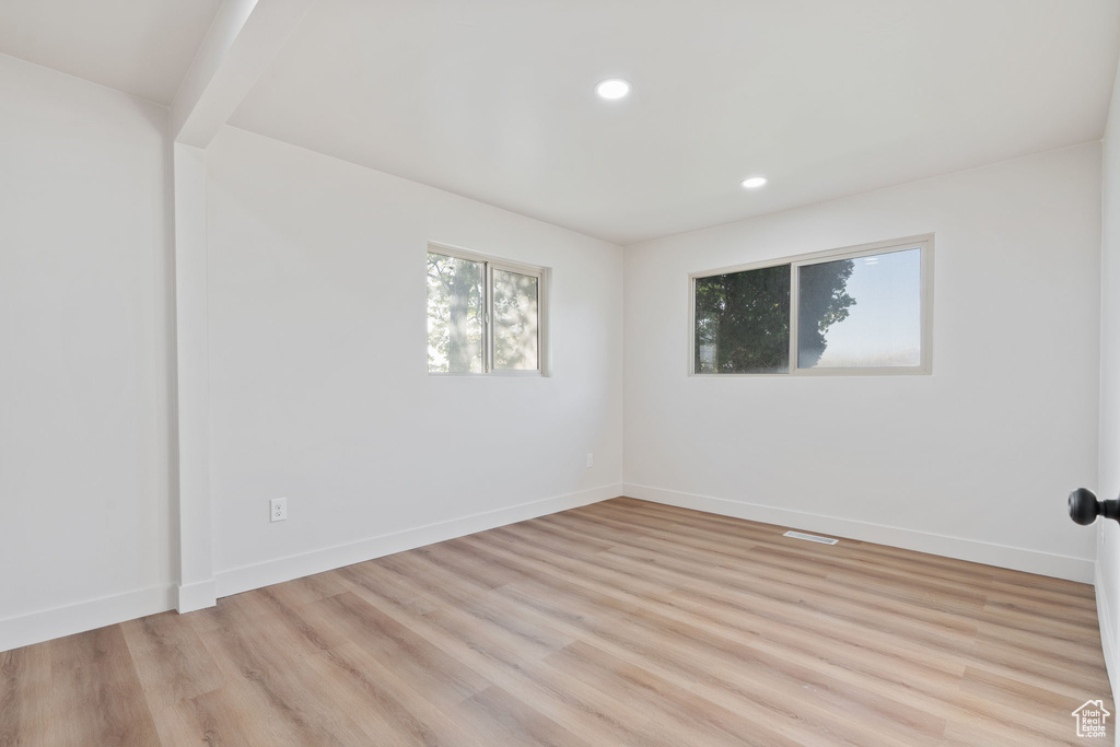 Empty room with baseboards, light wood finished floors, and recessed lighting