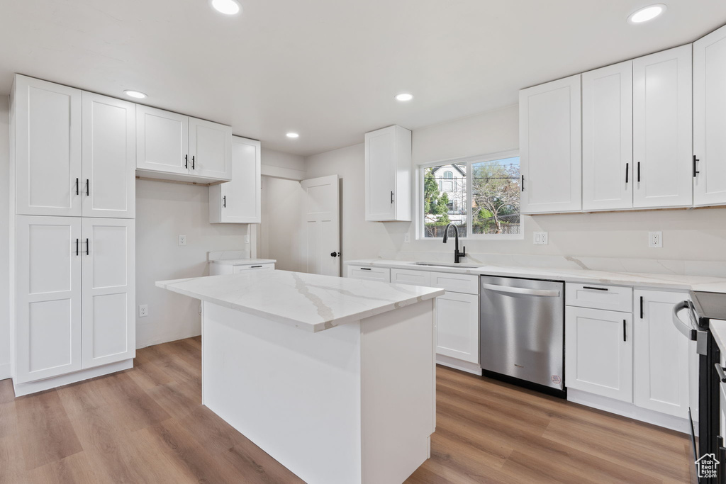 Kitchen featuring light stone countertops, dishwasher, a sink, recessed lighting, and white cabinetry