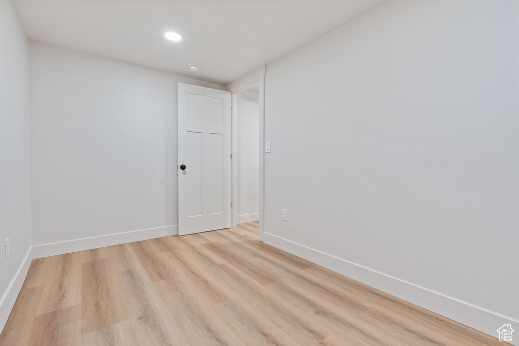 Unfurnished room with light wood-type flooring, recessed lighting, and baseboards
