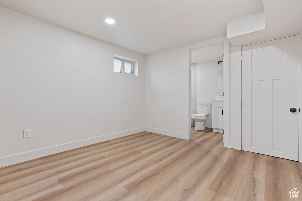 Unfurnished bedroom with light wood-type flooring, recessed lighting, baseboards, and ensuite bathroom