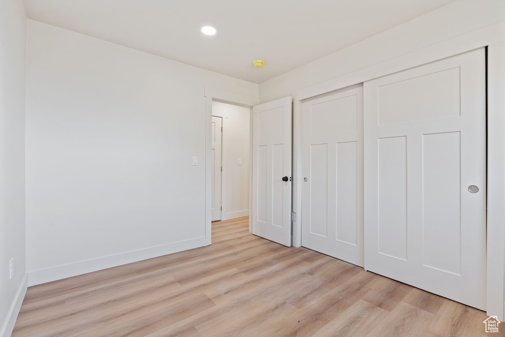 Unfurnished bedroom with light wood-type flooring, recessed lighting, baseboards, and a closet