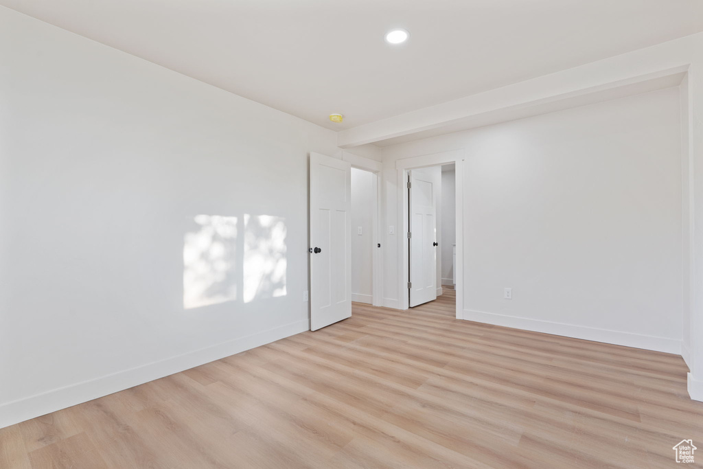 Spare room featuring baseboards, recessed lighting, and light wood-style flooring