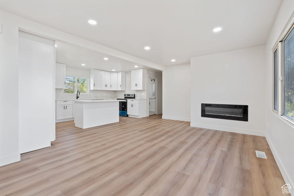 Unfurnished living room featuring recessed lighting, light wood-type flooring, and visible vents
