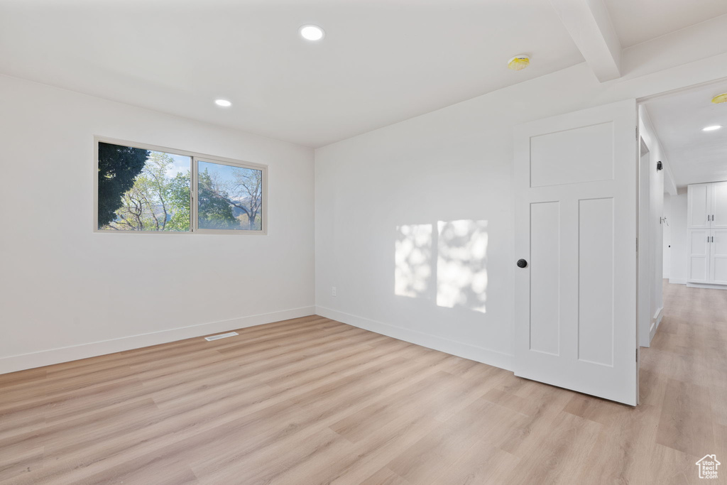 Empty room featuring recessed lighting, baseboards, visible vents, and light wood finished floors
