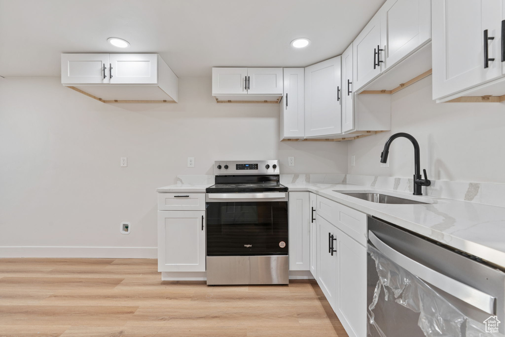 Kitchen featuring a sink, appliances with stainless steel finishes, and white cabinets