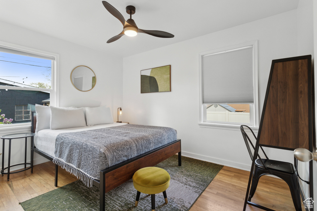 Bedroom with a ceiling fan, baseboards, and wood finished floors