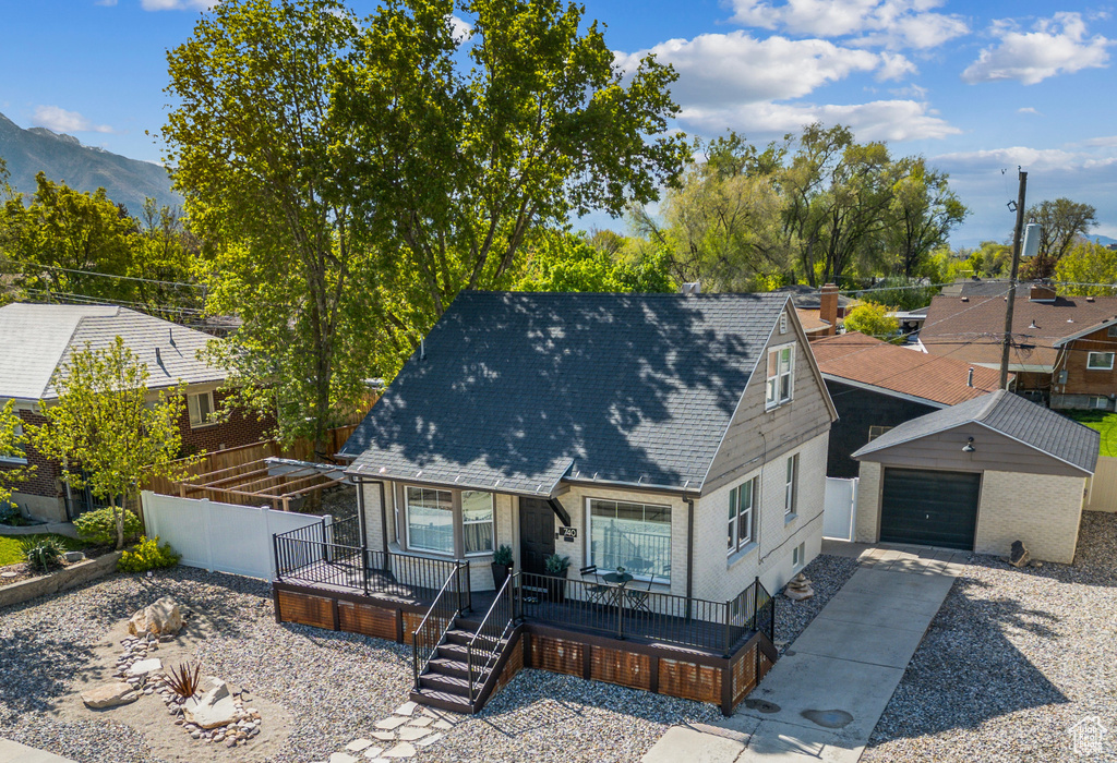 View of front facade featuring a garage, fence, a mountain view, concrete driveway, and a shingled roof
