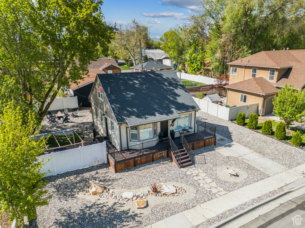 View of front of home with a porch, a shingled roof, and a fenced backyard