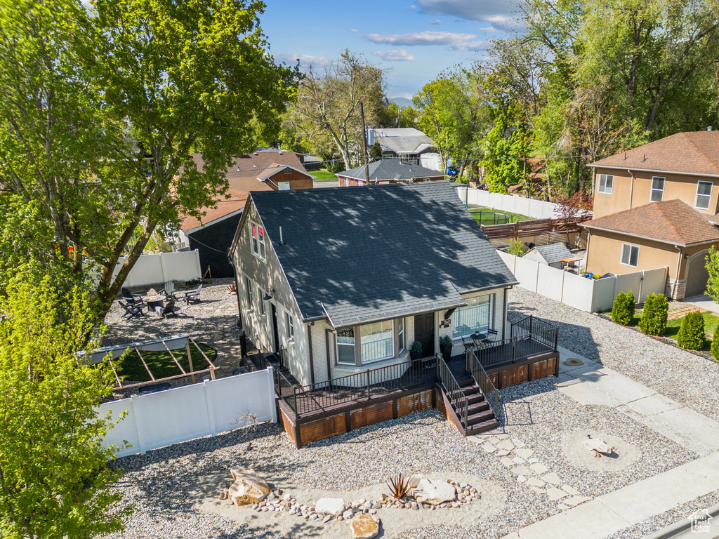 View of front of home with a porch, a shingled roof, and a fenced backyard