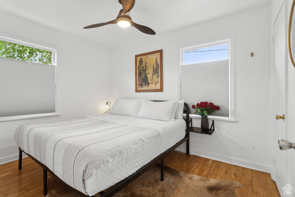 Bedroom featuring a ceiling fan, baseboards, and hardwood / wood-style floors