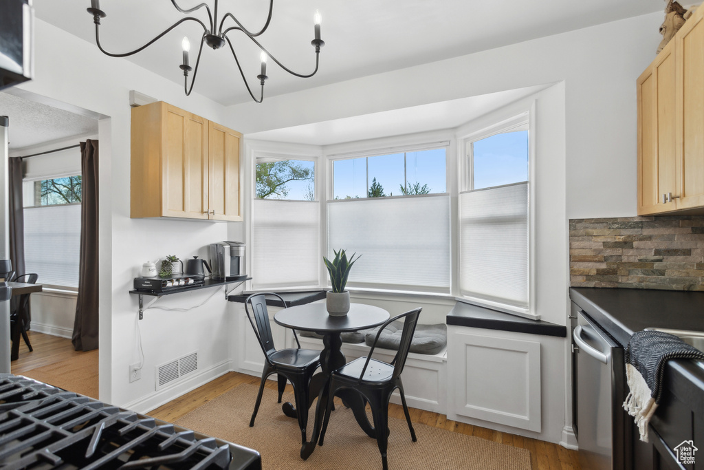 Kitchen featuring visible vents, light wood-style flooring, a notable chandelier, and light brown cabinets