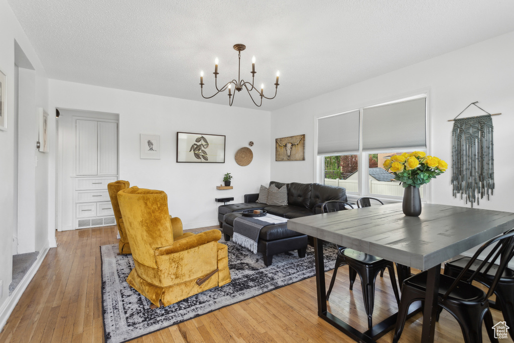 Living area with an inviting chandelier, baseboards, and hardwood / wood-style flooring