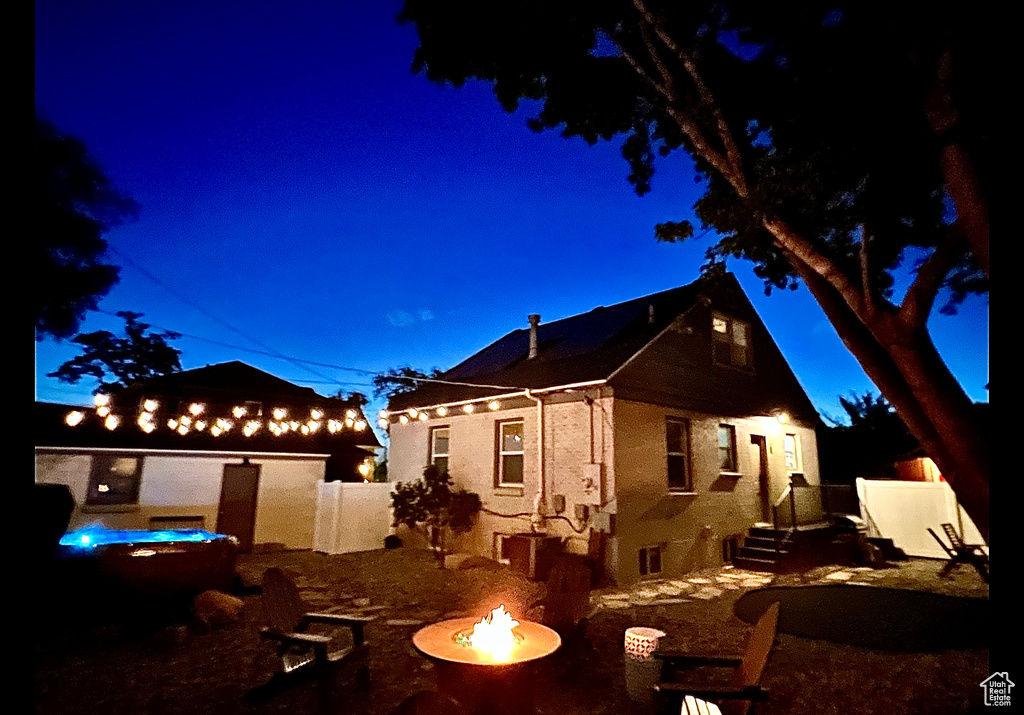 View of front of property with a patio area, an outdoor fire pit, and fence