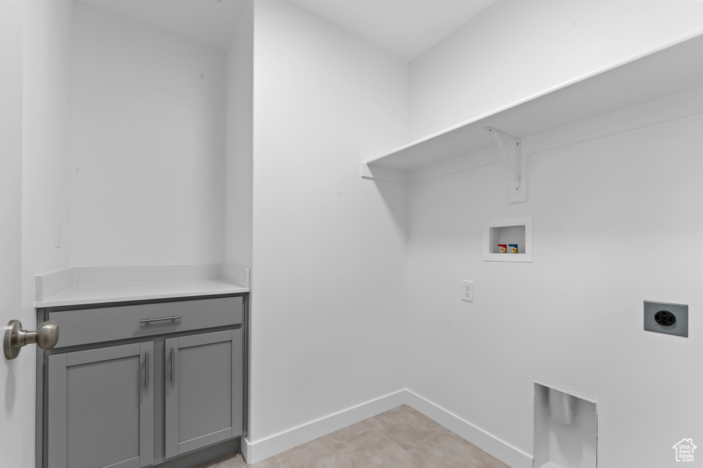 Washroom with baseboards, hookup for an electric dryer, cabinet space, and hookup for a washing machine