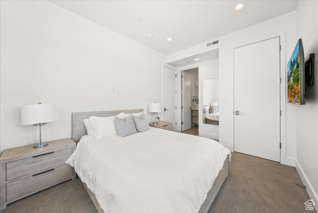 Carpeted bedroom with visible vents, recessed lighting, and baseboards