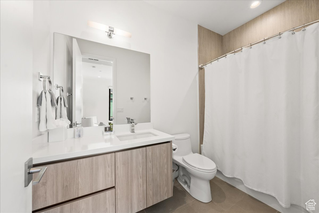 Full bath with vanity, tile patterned floors, toilet, and a shower with shower curtain