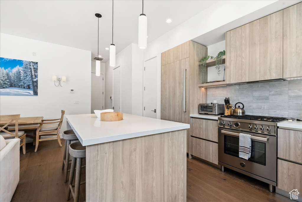 Kitchen featuring light brown cabinetry, modern cabinets, and high end range