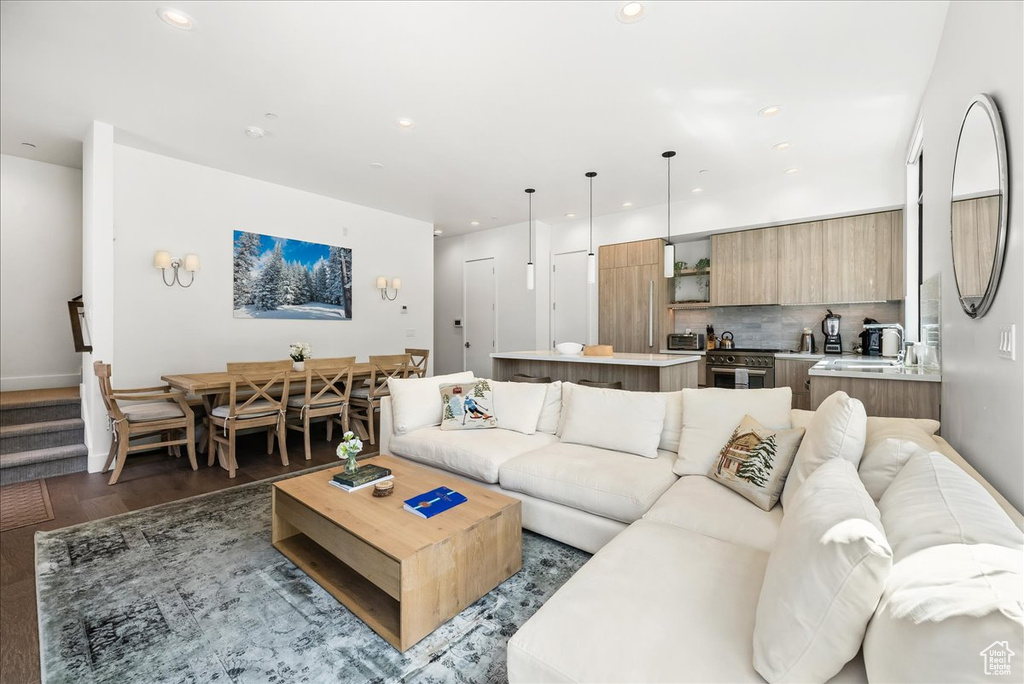 Living area featuring recessed lighting, dark wood-style flooring, and baseboards