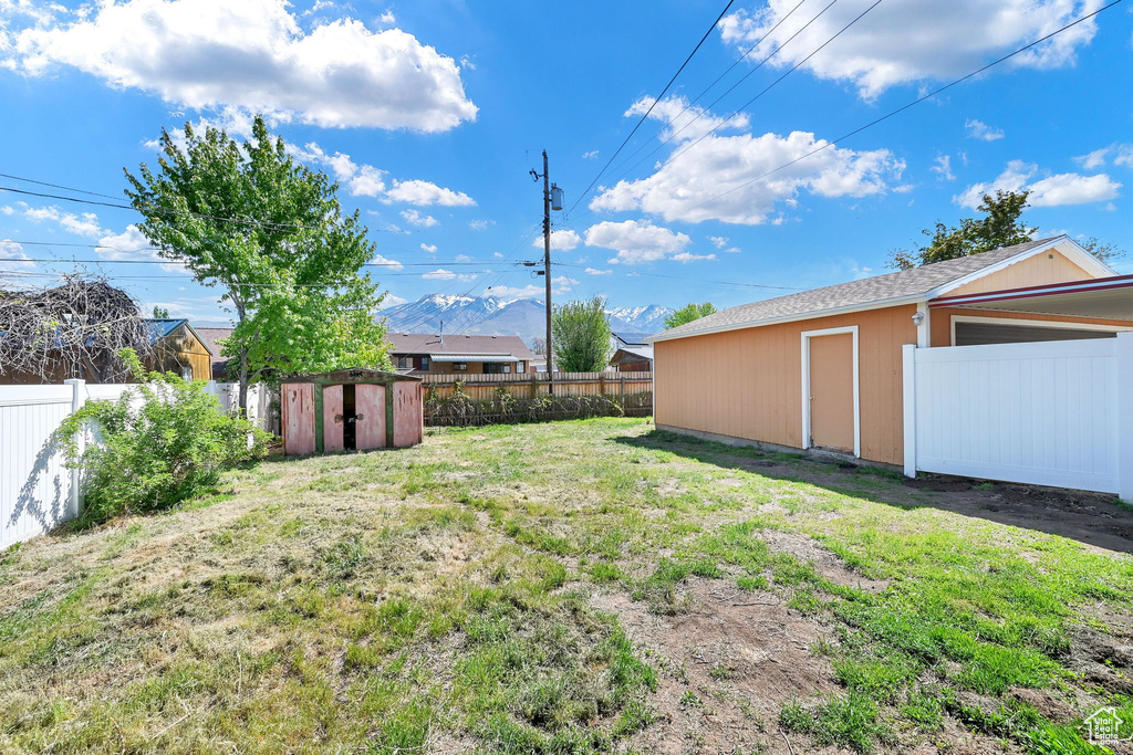 View of yard with a fenced backyard, an outbuilding, and a shed