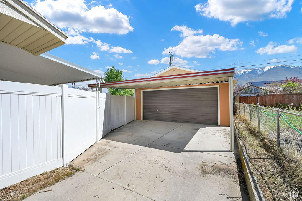 Garage featuring a detached garage, fence, and a mountain view