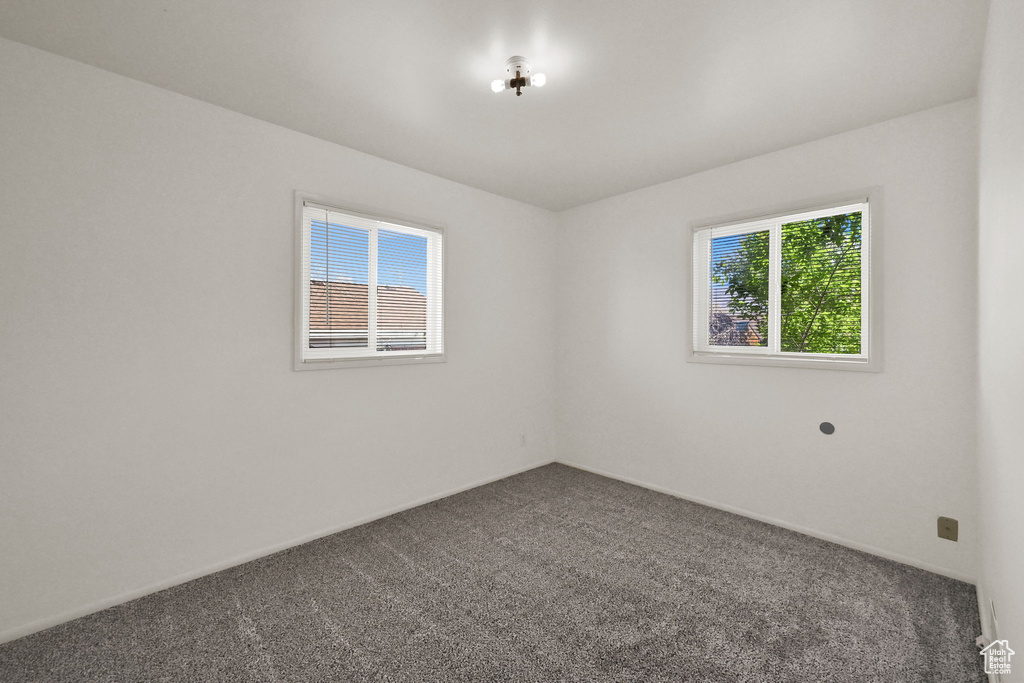 Empty room with carpet floors and baseboards