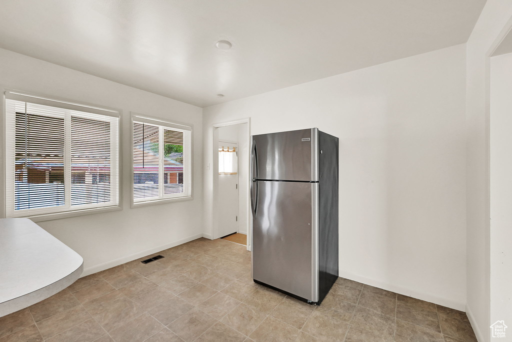 Kitchen with visible vents, freestanding refrigerator, and baseboards