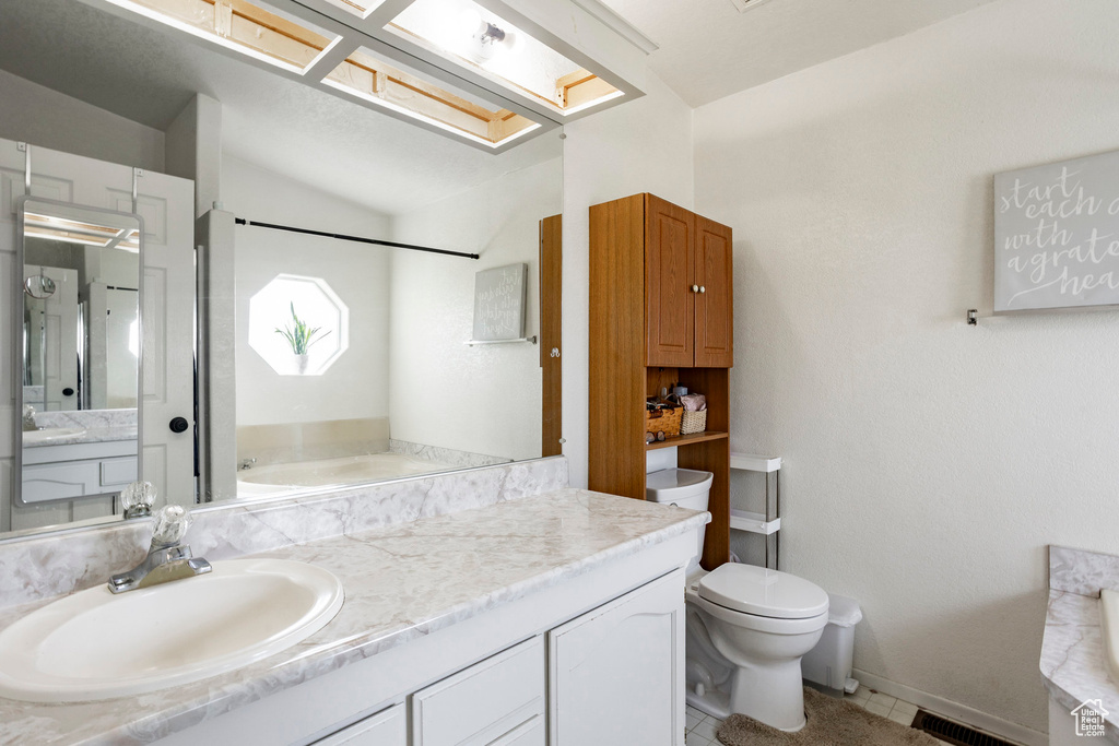 Bathroom with vanity, tile patterned flooring, visible vents, toilet, and vaulted ceiling