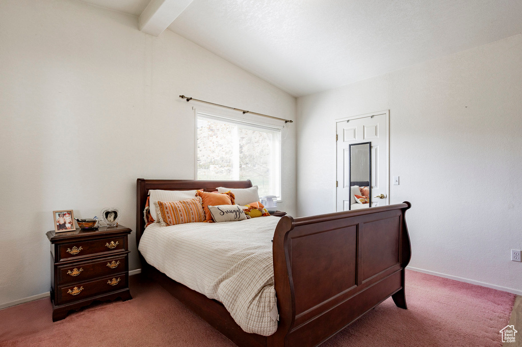 Bedroom with baseboards, lofted ceiling with beams, and carpet flooring