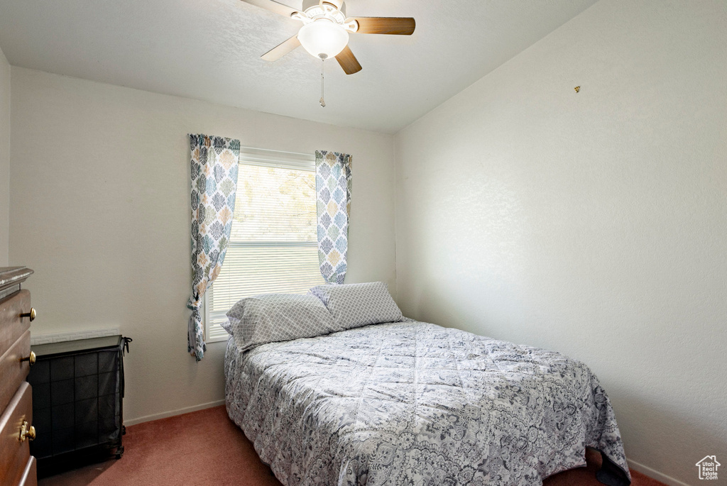 Bedroom featuring a ceiling fan, baseboards, and carpet