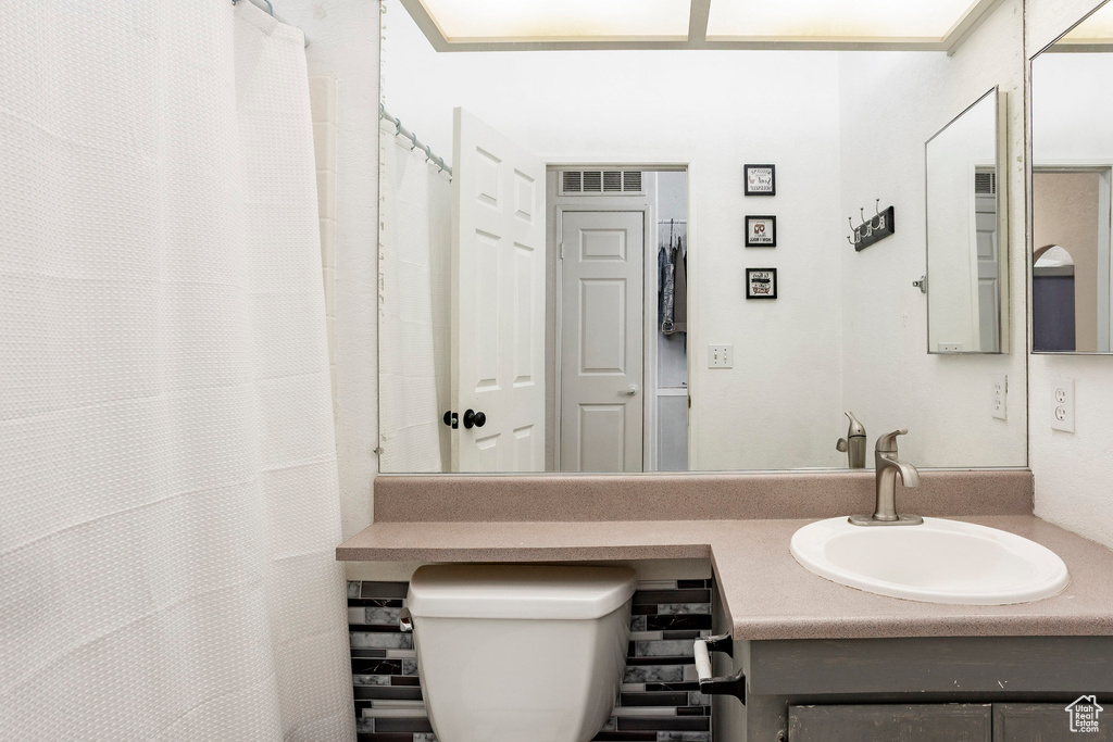 Full bathroom featuring vanity, toilet, and visible vents